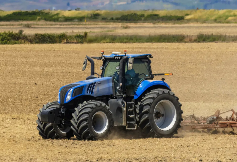 trator azul parado em um campo