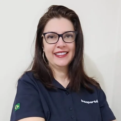 Kelly vendedora caminhao de braços cruzado, sorriso e sua camisa é da cor azul marinho.