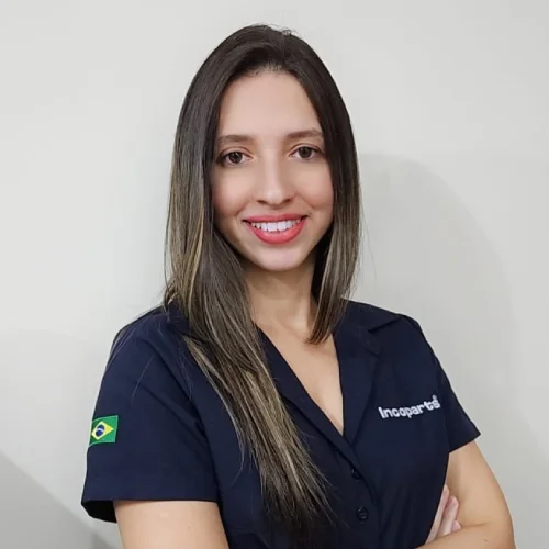 Pauliana vendedora caminhao de braços cruzado, sorriso e sua camisa é da cor azul marinho.